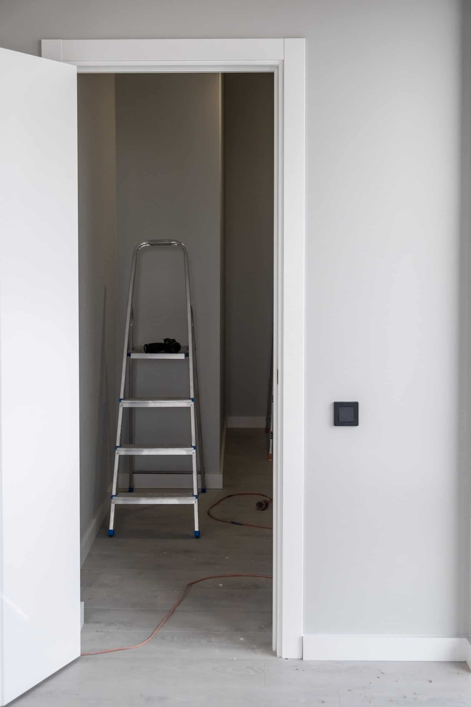 Interior wall with fresh white paint and doorway, professional drywall finishing.