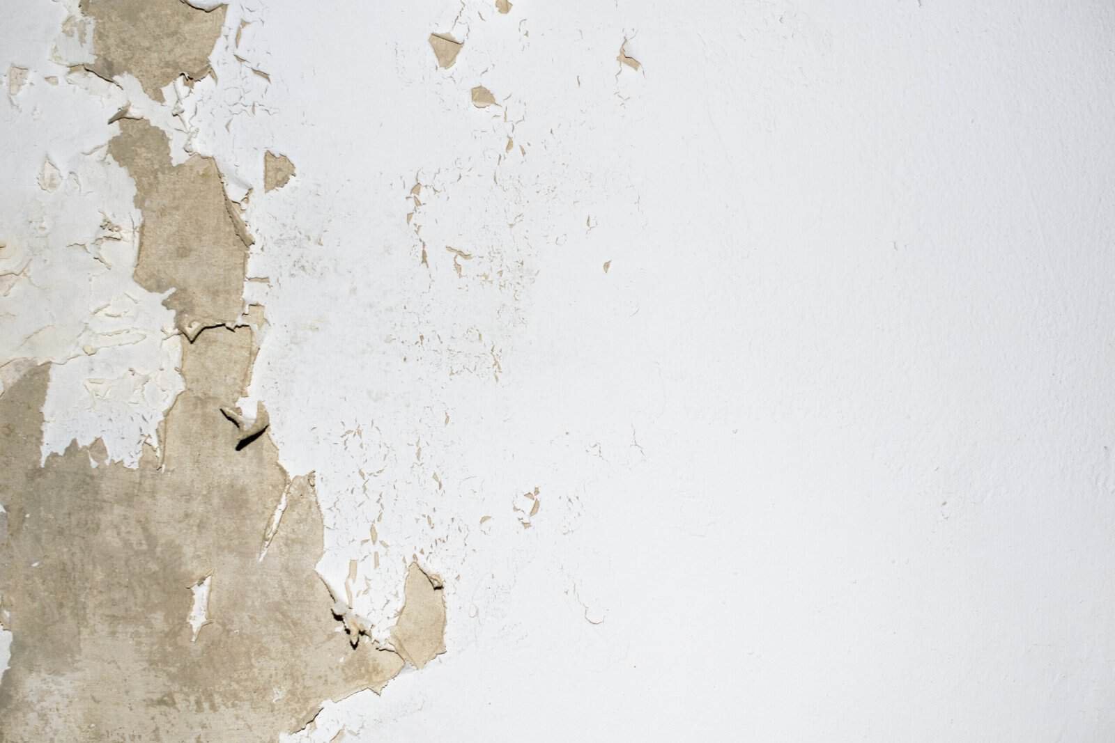 Damaged wall with peeling paint and drywall cracks in Southern California.